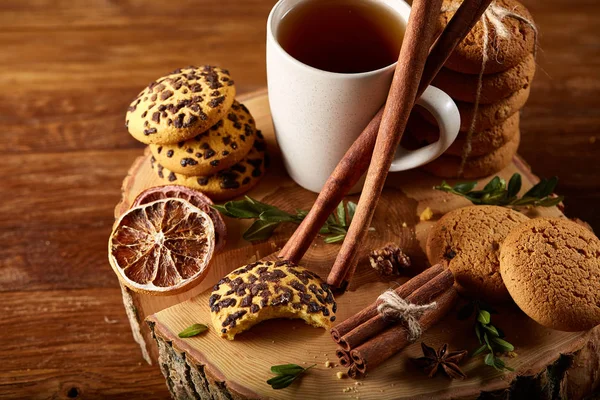 Bir fincan sıcak çay, kurabiye ve dekorasyon ahşap arka plan, seçici odak üzerinde bir oturum ile Noel kavramı