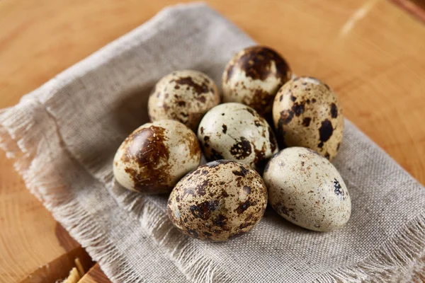 Bir günlük bir peçeteye yuvarlağına düzenlenmiş ahşap arka plan, yakın çekim, seçici odak bıldırcın yumurtası.
