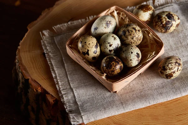 Yumurtalar bıldırcın kutusunun kompozisyon yumurta bir günlük saf bir peçeteye üzerinde ahşap arka plan üzerinde Üstten Görünüm