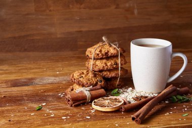 Bir fincan sıcak çay, kurabiye ve dekorasyon ahşap arka plan, seçici odak üzerinde bir oturum ile Noel kavramı