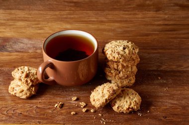 Porselen fincan çay ve tatlı kurabiye ahşap arka plan, üstten görünüm, seçici odak