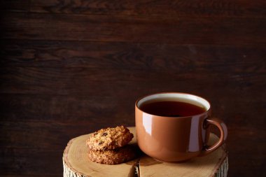 Bir fincan sıcak çay, kurabiye ve dekorasyon ahşap arka plan, seçici odak üzerinde bir oturum ile Noel kavramı