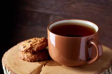 Bir fincan sıcak çay, kurabiye ve dekorasyon ahşap arka plan, seçici odak üzerinde bir oturum ile Noel kavramı