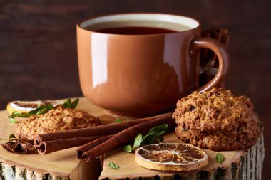 Bir fincan sıcak çay, kurabiye ve dekorasyon ahşap arka plan, seçici odak üzerinde bir oturum ile Noel kavramı