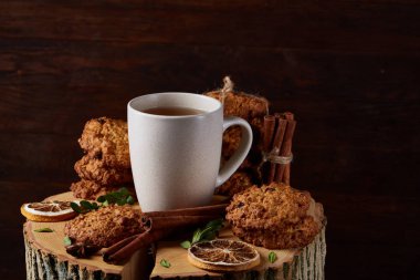 Bir fincan sıcak çay, kurabiye ve dekorasyon ahşap arka plan, seçici odak üzerinde bir oturum ile Noel kavramı