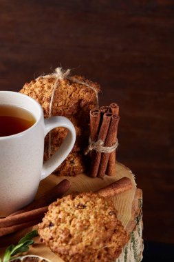 Bir fincan sıcak çay, kurabiye ve dekorasyon ahşap arka plan, seçici odak üzerinde bir oturum ile Noel kavramı