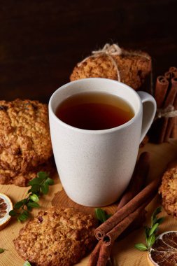 Bir fincan sıcak çay, kurabiye ve dekorasyon ahşap arka plan, seçici odak üzerinde bir oturum ile Noel kavramı