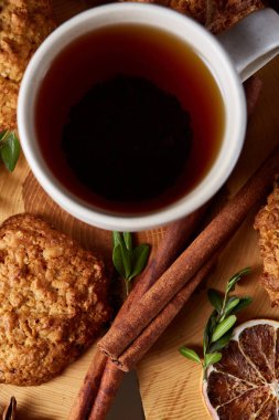 Bir fincan sıcak çay, kurabiye ve dekorasyon ahşap arka plan, seçici odak üzerinde bir oturum ile Noel kavramı