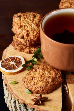 Bir fincan sıcak çay, kurabiye ve dekorasyon ahşap arka plan, seçici odak üzerinde bir oturum ile Noel kavramı