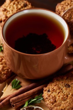 Bir fincan sıcak çay, kurabiye ve dekorasyon ahşap arka plan, seçici odak üzerinde bir oturum ile Noel kavramı