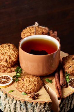 Bir fincan sıcak çay, kurabiye ve dekorasyon ahşap arka plan, seçici odak üzerinde bir oturum ile Noel kavramı