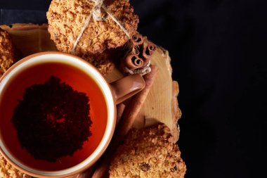 Bir fincan sıcak çay, kurabiye ve dekorasyon ahşap arka plan, seçici odak üzerinde bir oturum ile Noel kavramı