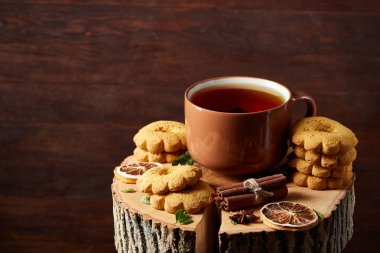 Bir fincan sıcak çay, kurabiye ve dekorasyon ahşap arka plan, seçici odak üzerinde bir oturum ile Noel kavramı