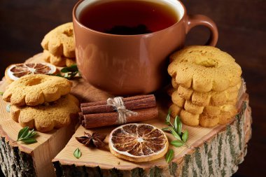 Bir fincan sıcak çay, kurabiye ve dekorasyon ahşap arka plan, seçici odak üzerinde bir oturum ile Noel kavramı