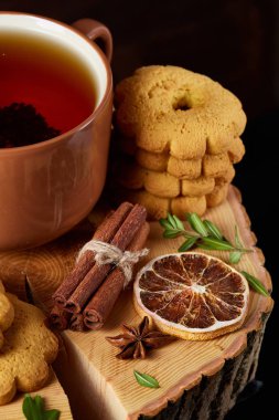 Bir fincan sıcak çay, kurabiye ve dekorasyon ahşap arka plan, seçici odak üzerinde bir oturum ile Noel kavramı