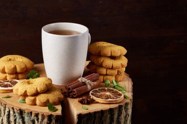 Bir fincan sıcak çay, kurabiye ve dekorasyon ahşap arka plan, seçici odak üzerinde bir oturum ile Noel kavramı