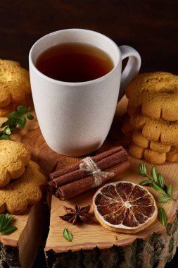 Bir fincan sıcak çay, kurabiye ve dekorasyon ahşap arka plan, seçici odak üzerinde bir oturum ile Noel kavramı