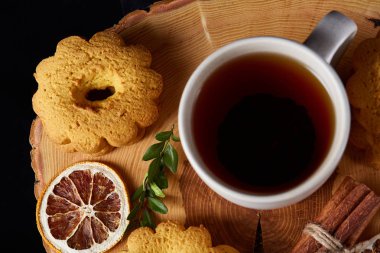 Bir fincan sıcak çay, kurabiye ve dekorasyon ahşap arka plan, seçici odak üzerinde bir oturum ile Noel kavramı