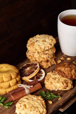 Kavramsal şenlikli bileşimi ile bir fincan sıcak çay, kurabiye ve spicies bir ahşap varil, seçici odak, yakın çekim