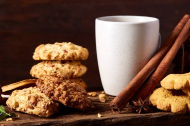 Kavramsal şenlikli bileşimi ile bir fincan sıcak çay, kurabiye ve spicies bir ahşap varil, seçici odak, yakın çekim