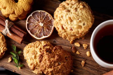 Kavramsal şenlikli bileşimi ile bir fincan sıcak çay, kurabiye ve spicies bir ahşap varil, seçici odak, yakın çekim