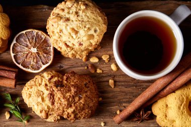 Kavramsal şenlikli bileşimi ile bir fincan sıcak çay, kurabiye ve spicies bir ahşap varil, seçici odak, yakın çekim