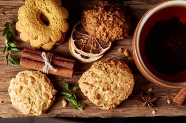 Kavramsal şenlikli bileşimi ile bir fincan sıcak çay, kurabiye ve spicies bir ahşap varil, seçici odak, yakın çekim