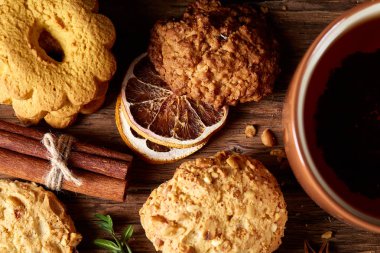 Kavramsal şenlikli bileşimi ile bir fincan sıcak çay, kurabiye ve spicies bir ahşap varil, seçici odak, yakın çekim