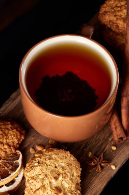 Kavramsal şenlikli bileşimi ile bir fincan sıcak çay, kurabiye ve spicies bir ahşap varil, seçici odak, yakın çekim