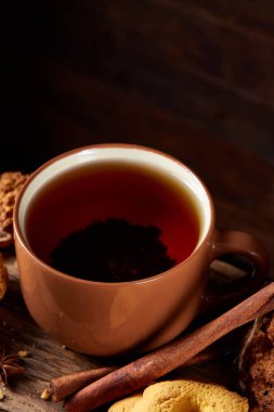 Kavramsal şenlikli bileşimi ile bir fincan sıcak çay, kurabiye ve spicies bir ahşap varil, seçici odak, yakın çekim