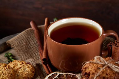 Kavramsal şenlikli bileşimi ile bir fincan sıcak çay, kurabiye ve spicies bir ahşap varil, seçici odak, yakın çekim