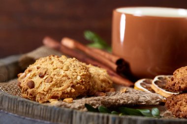 Kavramsal şenlikli bileşimi ile bir fincan sıcak çay, kurabiye ve spicies bir ahşap varil, seçici odak, yakın çekim