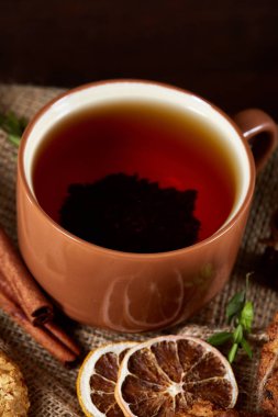 Kavramsal şenlikli bileşimi ile bir fincan sıcak çay, kurabiye ve spicies bir ahşap varil, seçici odak, yakın çekim