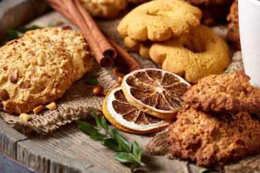 Kavramsal şenlikli bileşimi ile bir fincan sıcak çay, kurabiye ve spicies bir ahşap varil, seçici odak, yakın çekim