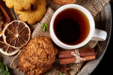 Kavramsal şenlikli bileşimi ile bir fincan sıcak çay, kurabiye ve spicies bir ahşap varil, seçici odak, yakın çekim