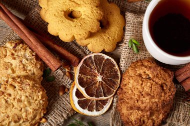 Kavramsal şenlikli bileşimi ile bir fincan sıcak çay, kurabiye ve spicies bir ahşap varil, seçici odak, yakın çekim