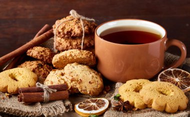 Bir fincan sıcak çay, kurabiye ve dekorasyon ahşap arka plan, seçici odak üzerinde bir oturum ile Noel kavramı