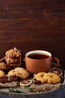 Bir fincan sıcak çay, kurabiye ve dekorasyon ahşap arka plan, seçici odak üzerinde bir oturum ile Noel kavramı