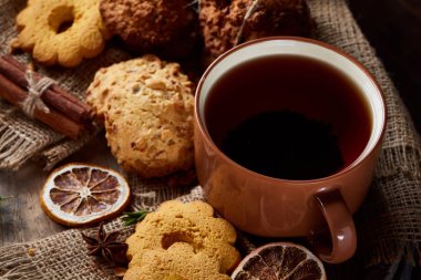 Bir fincan sıcak çay, kurabiye ve dekorasyon ahşap arka plan, seçici odak üzerinde bir oturum ile Noel kavramı