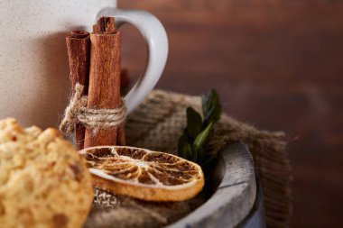 Beyaz porselen kupa çay ve tatlı kurabiye ahşap arka plan, üstten görünüm, seçici odak