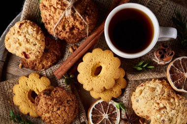 Beyaz porselen kupa çay ve tatlı kurabiye ahşap arka plan, üstten görünüm, seçici odak