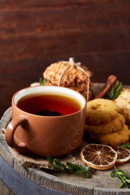 Bir fincan sıcak çay, kurabiye ve dekorasyon ahşap arka plan, seçici odak üzerinde bir oturum ile Noel kavramı