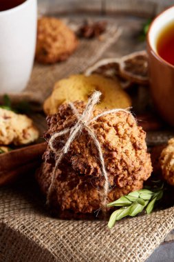 Bir fincan sıcak çay, kurabiye ve dekorasyon ahşap arka plan, seçici odak üzerinde bir oturum ile Noel kavramı