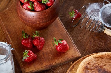 Yemek kek bir kabın içinde ahşap arka plan üzerinde seçici odak için çilek