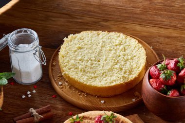 Top çilekli pasta ya da kek üzerine ahşap masa, düz yatıyordu yemek pişirmek için ham maddeler görüntüleyin. Fırın arka plan.