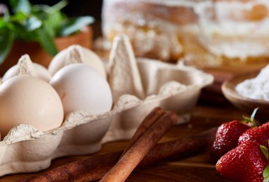 Top çilekli pasta ya da kek üzerine ahşap masa, düz yatıyordu yemek pişirmek için ham maddeler görüntüleyin. Fırın arka plan.