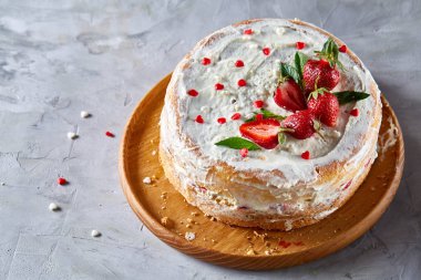 Çilek ve beyaz dokulu arka planda, seçici odak nane yaprakları ile süslenmiş krem şanti ile tart