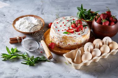 Çilekli tart beyaz arka plan üzerinde düz yatıyordu organik maddeler tarafından çevrili ekşi krem şanti ile kaplı.