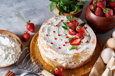 Çilekli tart beyaz arka plan üzerinde düz yatıyordu organik maddeler tarafından çevrili ekşi krem şanti ile kaplı.