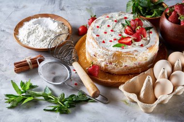 Çilekli tart beyaz arka plan üzerinde düz yatıyordu organik maddeler tarafından çevrili ekşi krem şanti ile kaplı.